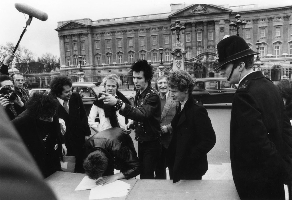 The Sex Pistols with their manager Malcolm McLaren signing a new contract with A&M Records after being dropped from EMI, outside Buckingham Palace, London, 10th March 1977. The contract was terminated after one week. (Photo by Graham Wood/Evening Standard/Hulton Archive/Getty Images)