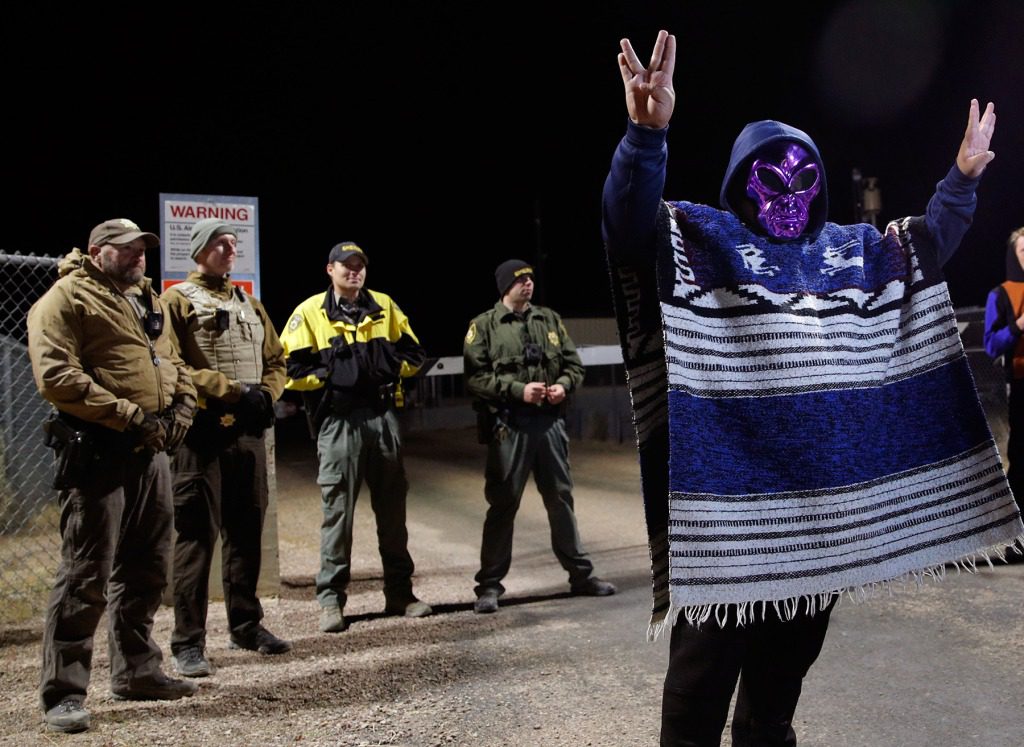 A man in an alien mask stands at an entrance to the Nevada Test and Training Range near Area 51 Friday, Sept. 20, 2019, outside of Rachel, Nev. People gathered at the gate inspired by the "Storm Area 51" internet hoax. (AP Photo/John Locher)