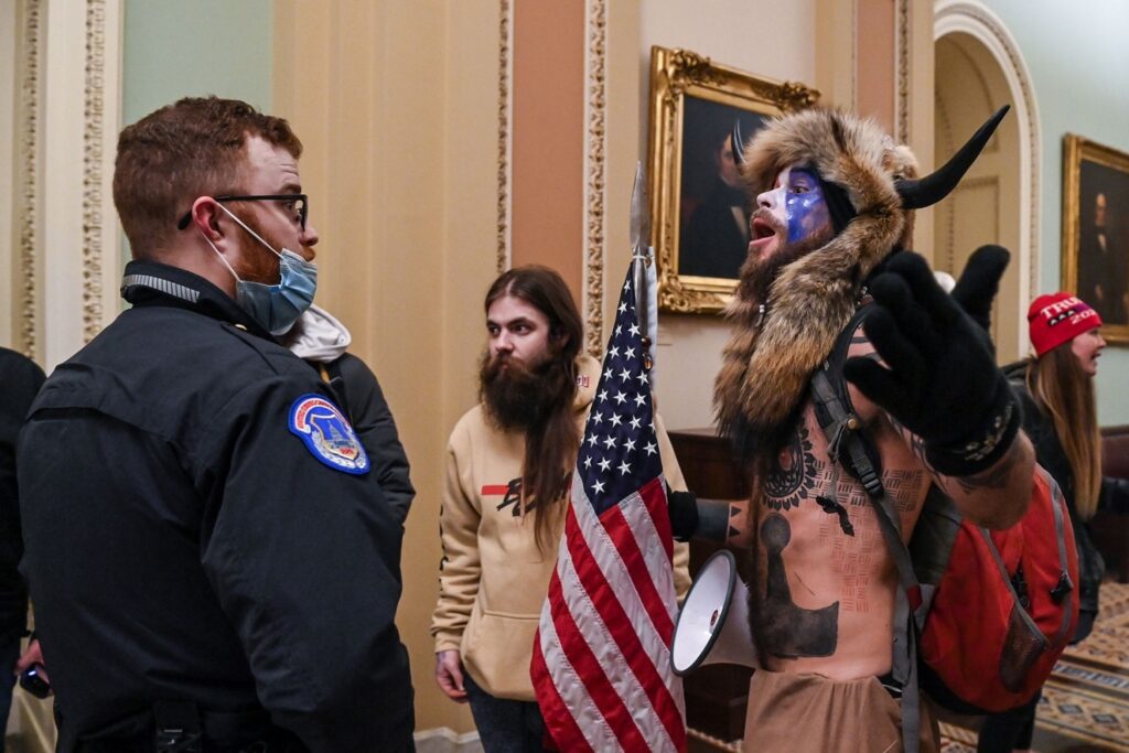 US Capitol police officers try to stop supporters of US President Donald Trump, including Jake Angeli (R), a QAnon supporter known for his painted face and horned hat, to enter the Capitol on January 6, 2021, in Washington, DC. - Demonstrators breeched security and entered the Capitol as Congress debated the a 2020 presidential election Electoral Vote Certification. (Photo by Saul LOEB / AFP) (Photo by SAUL LOEB/AFP via Getty Images)