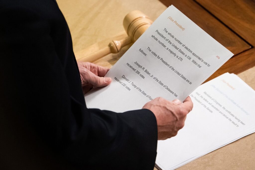 US Vice President Mike Pence reads a sheet of paper with the final electoral vote counts declaring Joe Biden as the next US President during a joint session of Congress to count the electoral votes for President, at the US Capitol in Washington, DC, January 7, 2021. - US lawmakers formally certified on January 7, Joe Biden as the winner of the presidential election -- clearing the way for his inauguration on January 20. Republican Vice President Mike Pence certified the Electoral College count of 306 electors in favor of the Democrat against 232 in favor of outgoing Republican President Donald Trump. The tally followed a joint session of the House and Senate that was interrupted by supporters of the president who stormed the US Capitol, bringing violence and mayhem to the seat of government. (Photo by SAUL LOEB / AFP) (Photo by SAUL LOEB/AFP via Getty Images)