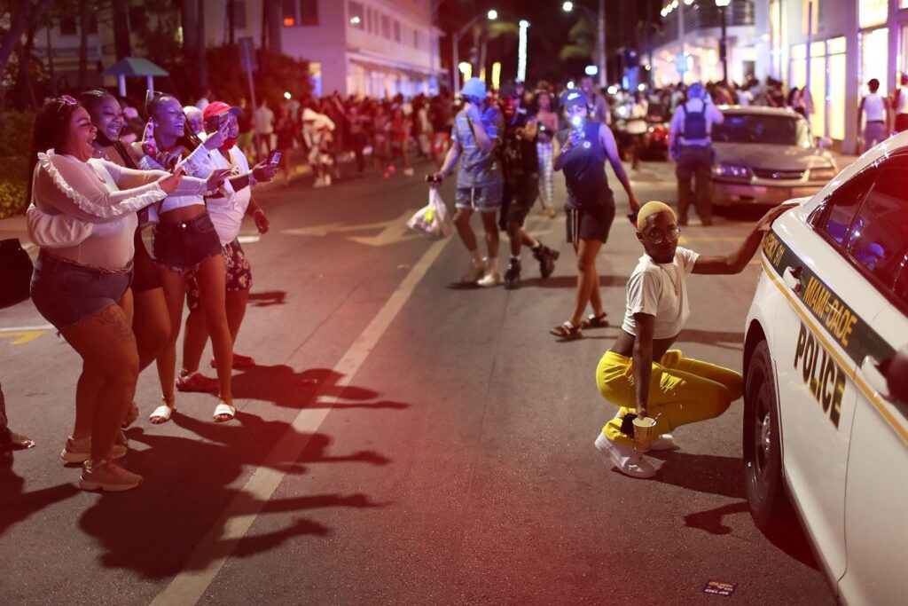 MIAMI BEACH, FLORIDA - MARCH 21: (EDITOR'S NOTE: Alternate crop) People leave the area as an 8pm curfew goes into effect on March 21, 2021 in Miami Beach, Florida. College students have arrived in the South Florida area for the annual spring break ritual, prompting city officials to impose an 8pm to 6am curfew as the coronavirus pandemic continues. Miami Beach police have reported hundreds of arrests and stepped up deployment to control the growing spring break crowds. (Photo by Joe Raedle/Getty Images)