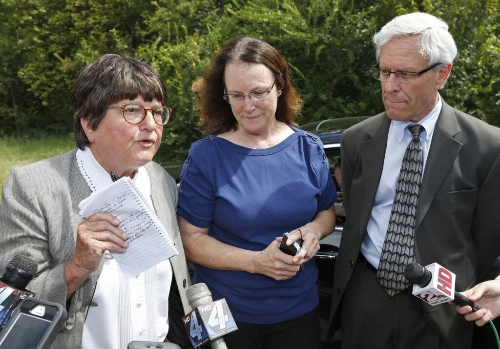 Kathleen Lord, center, and Don Knight, right, two of Richard Glossip's defense attorneys, look on as Sister Helen Prejean, left, addresses the media outside the Oklahoma State Penitentiary in McAlester Okla., Wednesday, Sept. 16, 2015, after a stay was issued for Glossip. Glossip was twice convicted of ordering the killing of Barry Van Treese, who owned the Oklahoma City motel where he worked. His co-worker, Justin Sneed, was convicted of fatally beating Van Treese and was a key prosecution witness in Glossip's trials. (AP Photo/Sue Ogrocki)