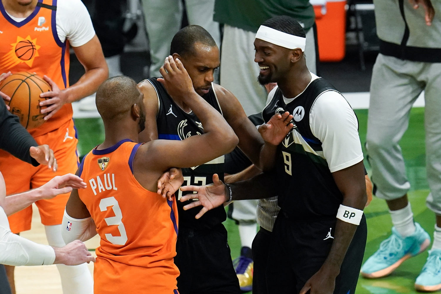 Phoenix Suns guard Chris Paul (3) is separated from Milwaukee Bucks center Bobby Portis (9) by Khris Middleton, center, during the second half of Game 6 of basketball's NBA Finals in Milwaukee, Tuesday, July 20, 2021. (AP Photo/Paul Sancya)