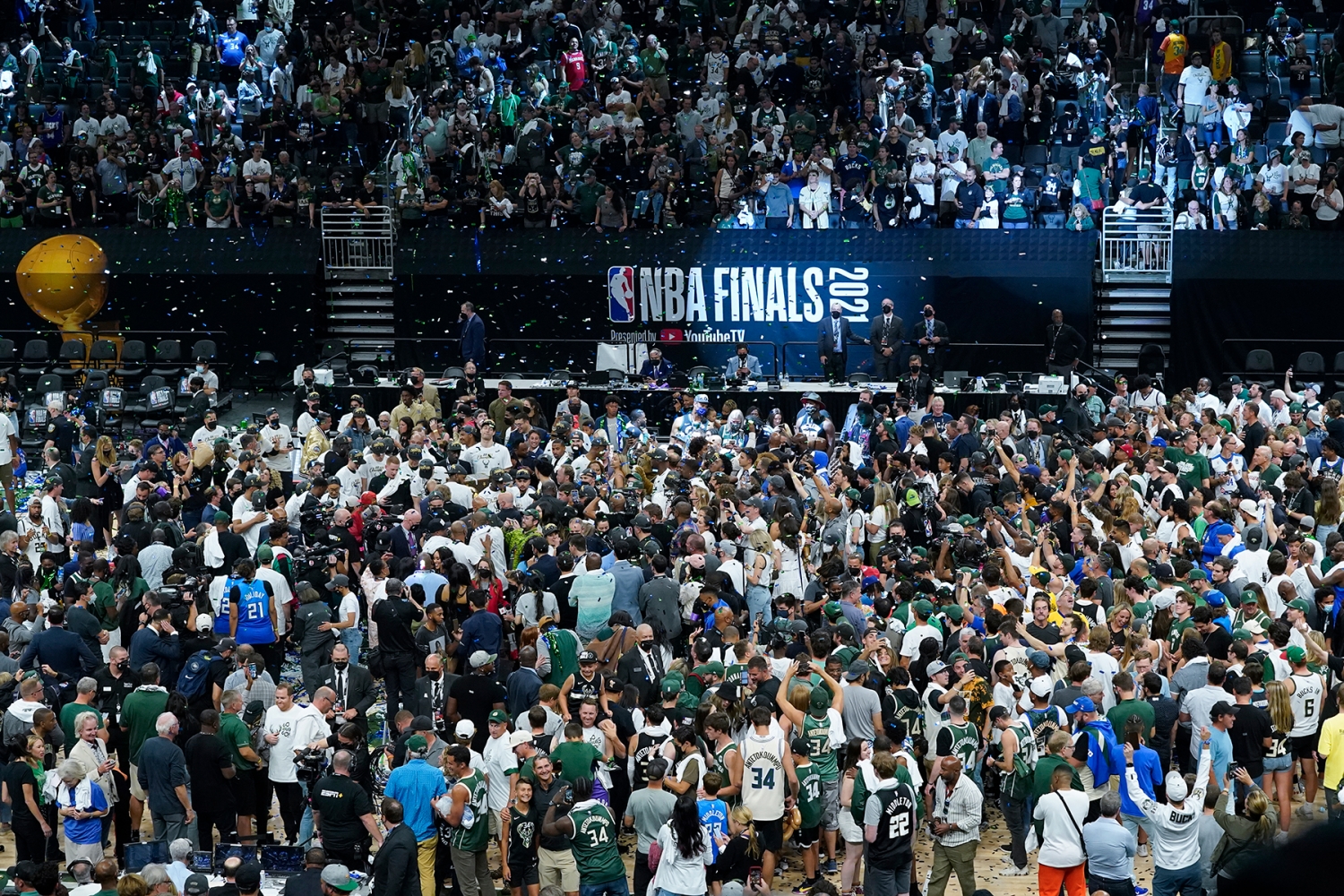 The court is covered with people in celebration after the Milwaukee Bucks beat the Phoenix Suns 105-98 in Game 6 of basketball's NBA Finals in Milwaukee, Tuesday, July 20, 2021. (AP Photo/Paul Sancya)