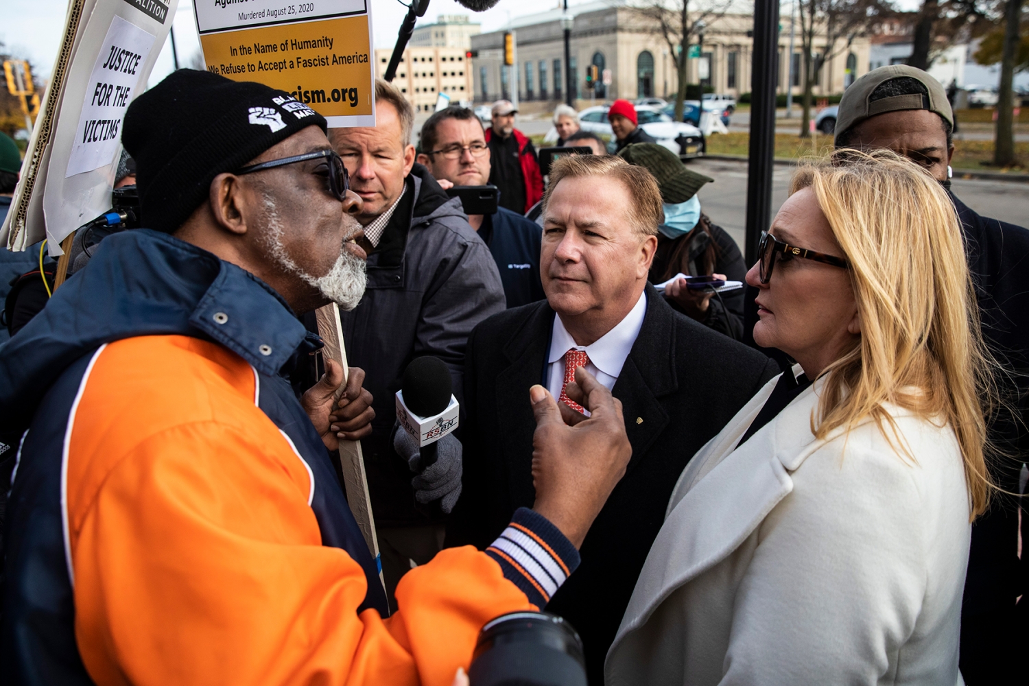 Clyde McLemore, left, founder of Black Lives Matter Lake County, speaks with Mark and Patricia McCloskey outside the Kenosha County Courthouse while the jury deliberates in the Kyle Rittenhouse case inside, in Kenosha, Wis. Tuesday, Nov. 16, 2021. Rittenhouse is accused of killing two people and wounding a third during a protest over police brutality in Kenosha, last year. (Ashlee Rezin /Chicago Sun-Times via AP)