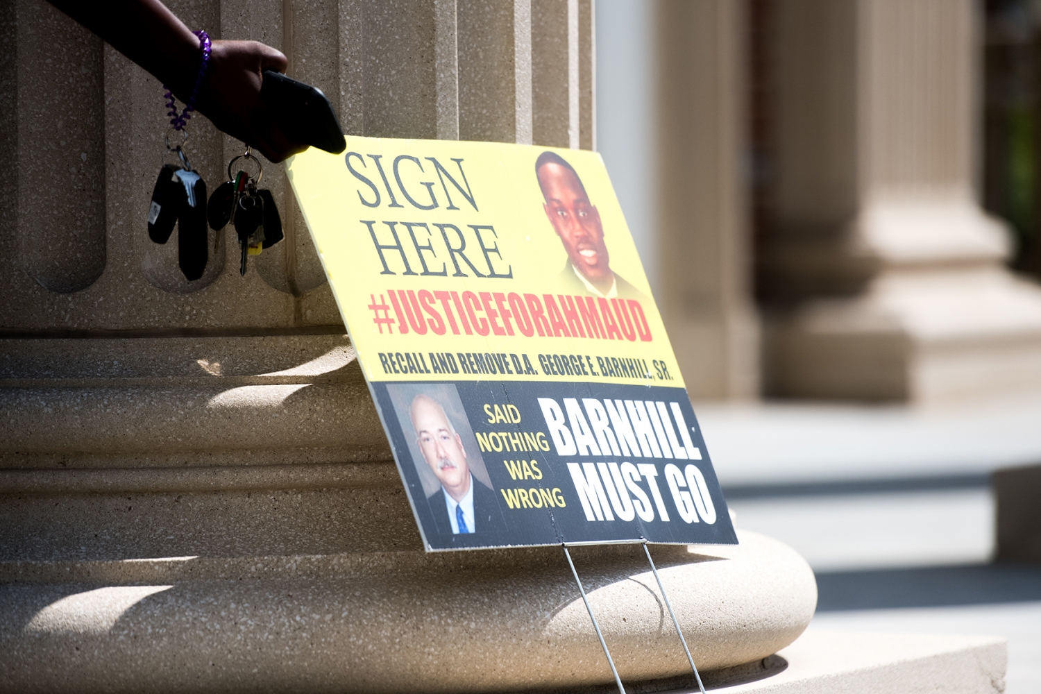 BRUNSWICK, GA - JULY 17: A sign calling for justice for Ahmaud Arbery, including the recall of District Attorney George Barnhill Sr. sits outside the Glynn County Courthouse on July 17, 2020 in Brunswick, Georgia. Gregory McMichael, Travis McMichael, and William 'Roddie' Bryan appeared before a judge for the murder of Ahmaud Arbery. (Photo by Sean Rayford/Getty Images)