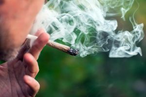 Man smokes a joint. Medical marijuana use and legalization of the cannabis, light drugs concept