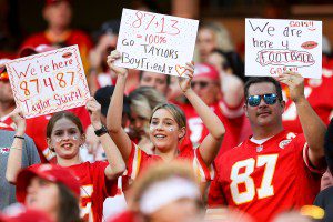 KANSAS CITY, MISSOURI - OCTOBER 22: Kansas City Chiefs fans hold signs for Taylor Swift and Travis Kelce #87 of the Kansas City Chiefs during an NFL football game against the Los Angeles Chargers at GEHA Field at Arrowhead Stadium on October 22, 2023 in Kansas City, Missouri. (Photo by Kara Durrette/Getty Images)